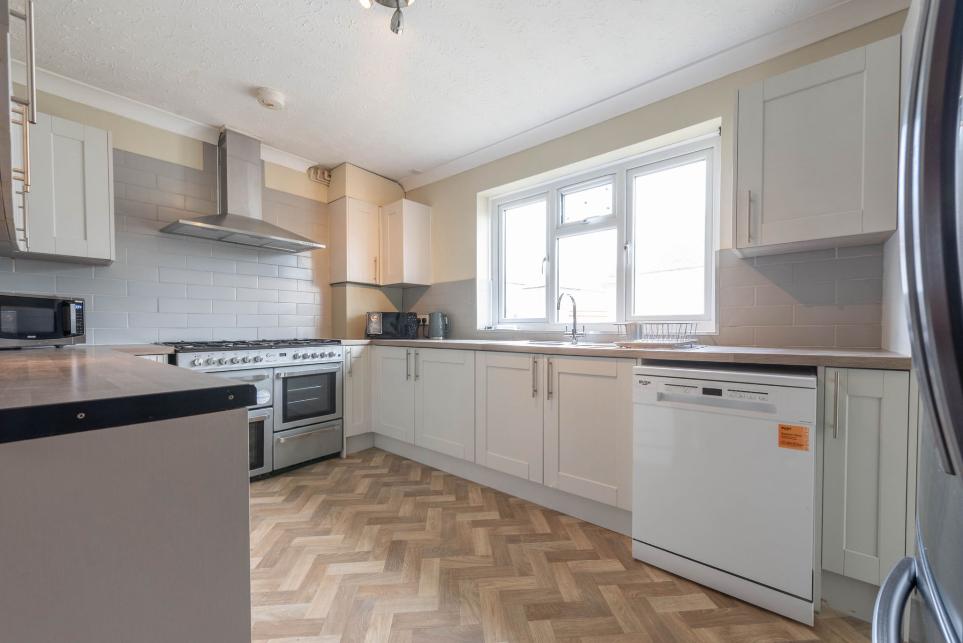 Finished white shaker kitchen with parquet flooring after renovation in Oxfordshire