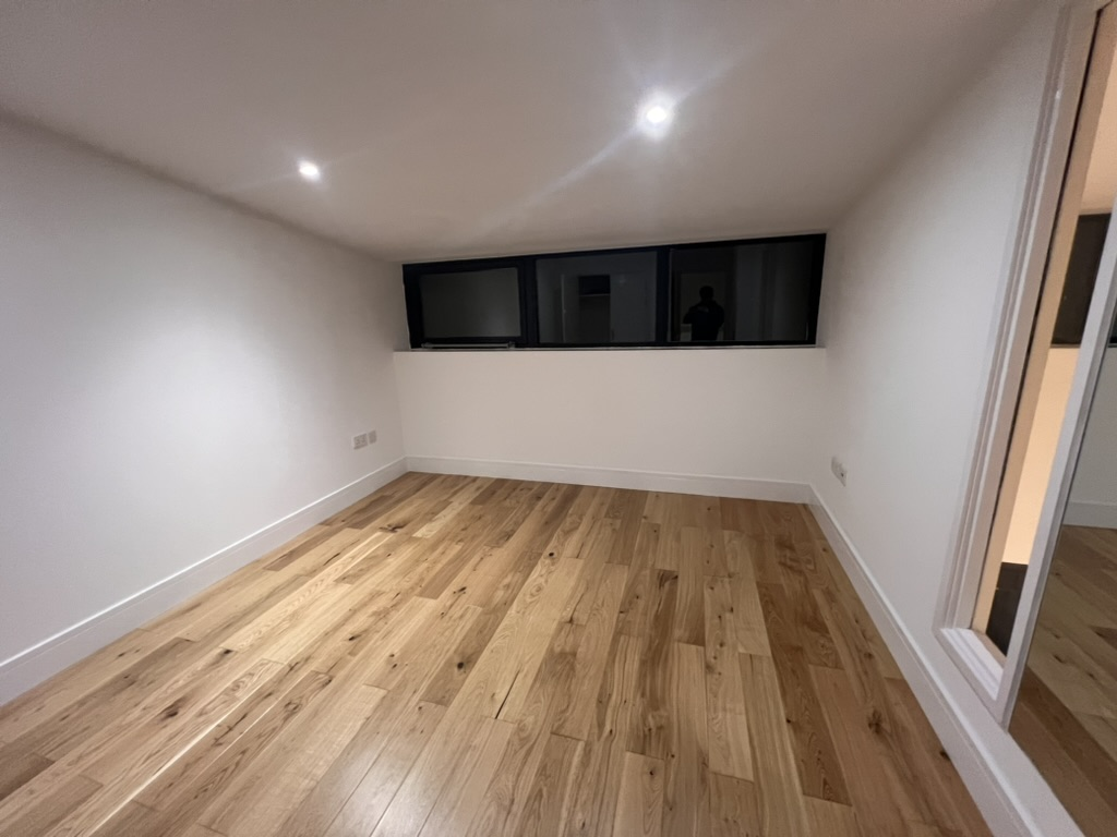 Empty loft bedroom with wooden flooring before styling