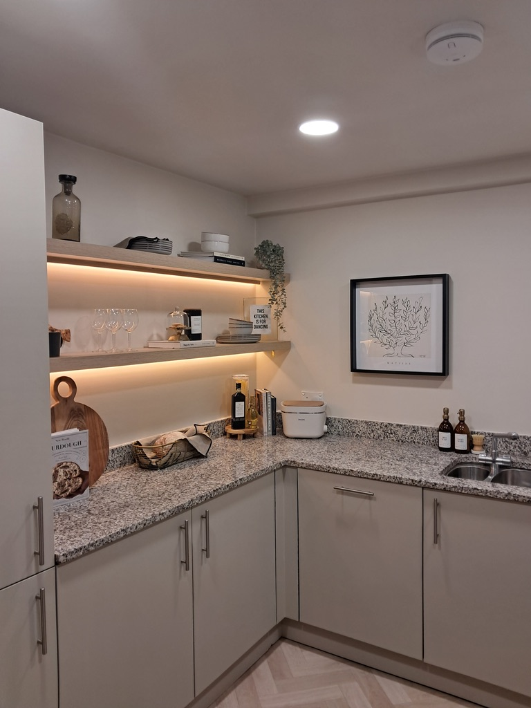 Finished kitchen with illuminated shelving and herringbone flooring after renovation