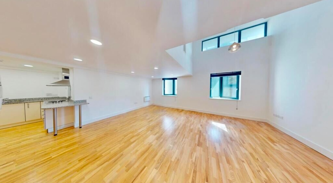 Empty double-height open-plan living space before refurbishment